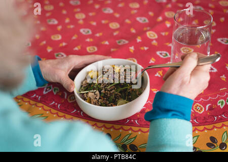 Senior woman having meal at home Stock Photo