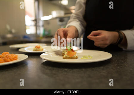 Chef garnishing food on plate Stock Photo