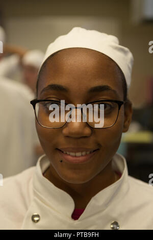 Female chef smiling in kitchen at restaurant Stock Photo