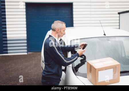 Delivery man using mobile phone Stock Photo