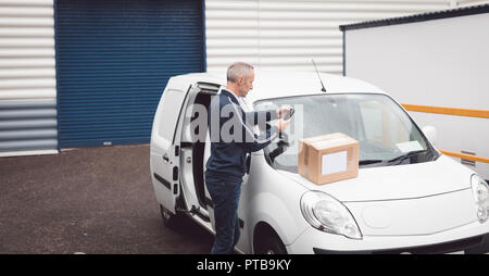 Delivery man using mobile phone Stock Photo