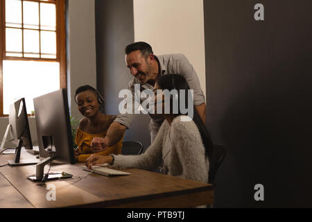Business colleagues discussing over a computer in office Stock Photo