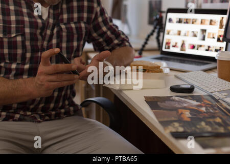 Businessman checking blood sugar with glucometer in office Stock Photo