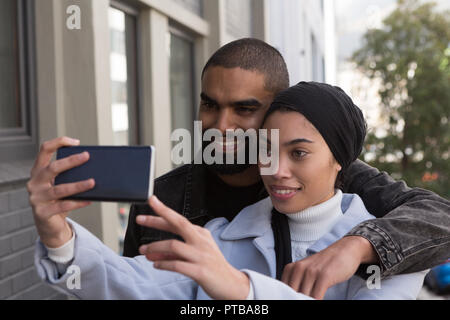 Couple taking selfie on city street Stock Photo
