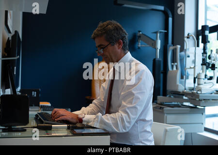 Optometrist using desktop pc in clinic Stock Photo