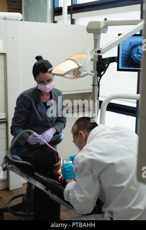 Male dentist examining a patient with tools Stock Photo