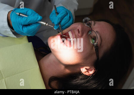 Male dentist examining a lady patient in clinic Stock Photo