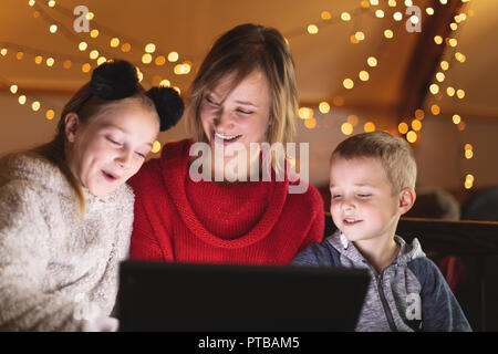 Smiling mother and kids using laptop at home Stock Photo