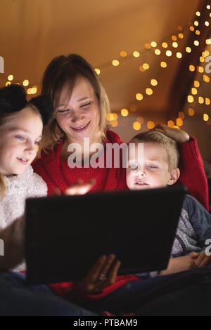 Smiling mother and kids using digital tablet at home Stock Photo