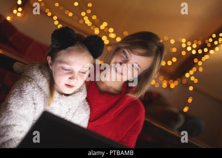 Mother and daughter using digital tablet at home Stock Photo