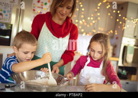 Mother and kids making Christmas cookies in kitchen Stock Photo