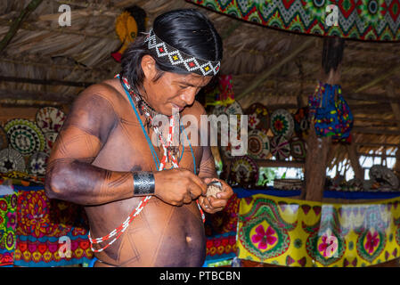 Central America, Panama, Gatun Lake. Embera Indian village. Male villager carving local handicrafts. Stock Photo