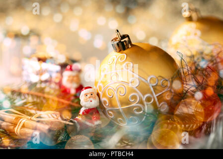 Golden bauble with Christmas decoration and little figure as Santa Claus Stock Photo