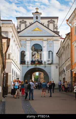 Chapel of the Gates of Dawn, in Vilnius Old Town people look towards a  chapel window disclosing the shrine of the Madonna of the Gates of Dawn. Stock Photo
