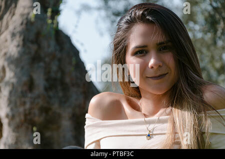 Beautiful smiling teenage girl, against green of summer park. Stock Photo