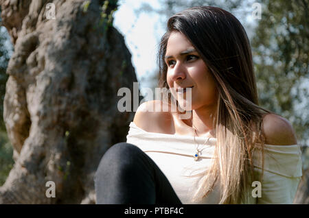 Beautiful smiling teenage girl, against green of summer park. Stock Photo