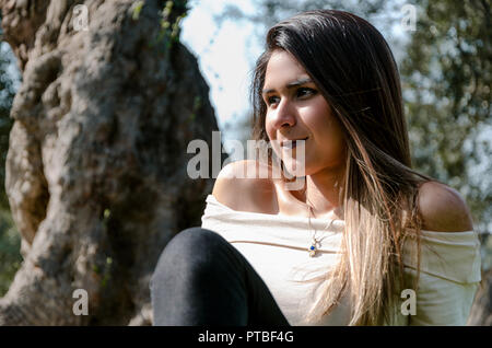 Beautiful smiling teenage girl, against green of summer park. Stock Photo