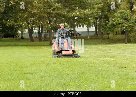 lawn mower tractor working in the town park Stock Photo
