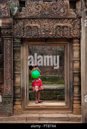 Cambodian little girl with a green balloon in Banteay Srei temple gate, Siem Reap Province, Angkor, Cambodia Stock Photo