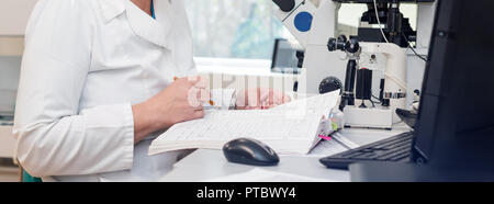 Doctor or scientist working with computer and microscope in biotech lab. Equipment in laboratory of Fertilization, IVF Stock Photo