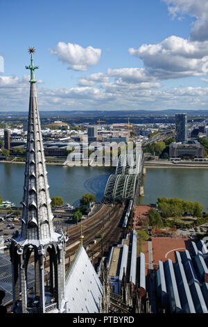 The impressive view east over the river Rhine and the Hohenzollern railway  bridge in Cologne city from the heights of the cathedral spires. Stock Photo