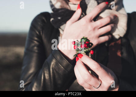 the girl holds a bouquet of red berries of cowberry in autumn time Stock Photo