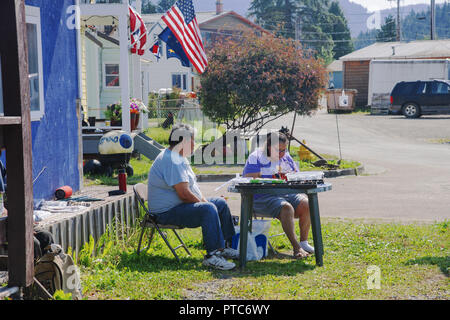 Local craftsmen offer their products to tourists sitting near their home. Hoonah, Alaska, USA Stock Photo