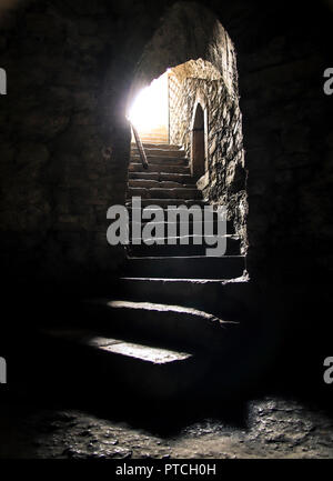 Underground room with bright light shining at the end of the staircase. Stock Photo