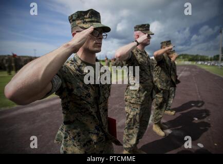 U.S. Marine Cpls. Otto Thiele, Eric Goodman, Christopher Ehms and Lance Cpl. Avelardo Guevara Osuna receive Navy and Marine Corps Achievement Medals from Col. Forrest Poole aboard Camp Kinser, Okinawa, Japan July, 11, 2017. The Marines came together to assist a local Japanese woman during their hike on Mount Fuji, Japan, July 3, 2017. The woman, Oda Moe, was found lying on the ground, hyperventilating and struggling to breathe when the Marines came to her assistance. Together, they created a makeshift stretcher to carry her down approximately two miles to get to medical assistance. The Marines Stock Photo