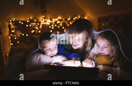 Mother and kids under the blanket using digital tablet Stock Photo