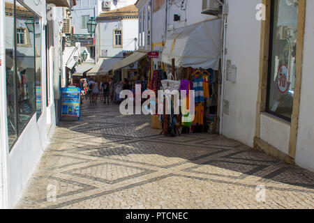 28 September 2018 Tourists stroll the cobbled streets of the Old Town in Albuferia on the Algarve in Portugal on a hot sunny afternoon Stock Photo