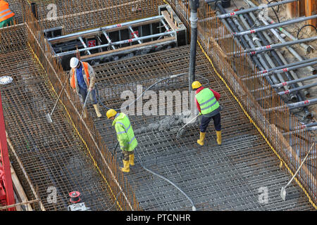 worker placing fresh concrete with tube valve Stock Photo