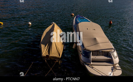 Italy, Lecco, Lake Como, covered boat resting on lake Stock Photo