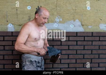 Bricklayer worker installing bricks on construction site. Stock Photo