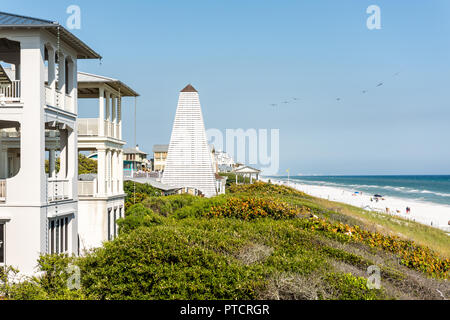 Seaside, USA - April 25, 2018: Wooden pavilions by beach ocean with coastline, gazebo in Florida, sand, architecture, view during sunny day, flock of  Stock Photo