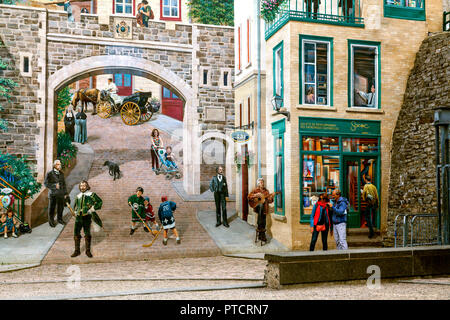 A huge wall painting in Old Quebec City, Canada. A couple of tourists are checking their photos taken in front of the wall. Along Rue Notre Dame. Stock Photo