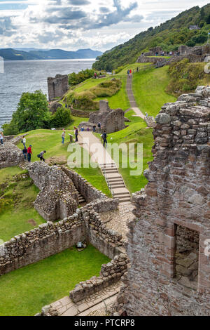 Tourists explore the ruins of Urquhart Castle along the shores of Loch Ness, Highlands, Scotland Stock Photo