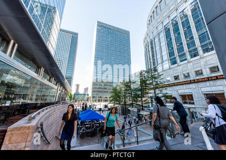 London, UK - June 26, 2018: People crowd commuters outside metro entrance during morning commute in Canary Wharf Docklands with modern architecture, r Stock Photo