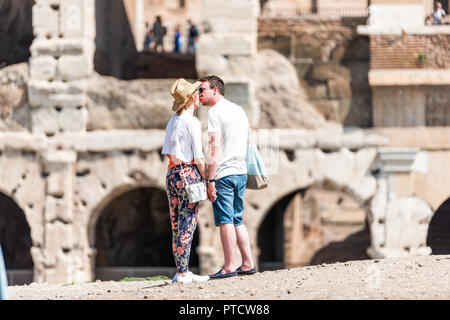 Rome, Italy - September 4, 2018: Historic city with Colosseum, sunny summer day, people romantic couple on street kissing in front of stone walls of A Stock Photo