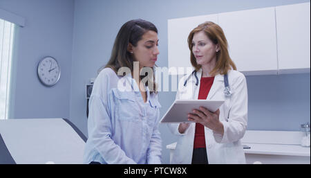 Closeup of doctor using high tech tablet to review health history with patient Stock Photo