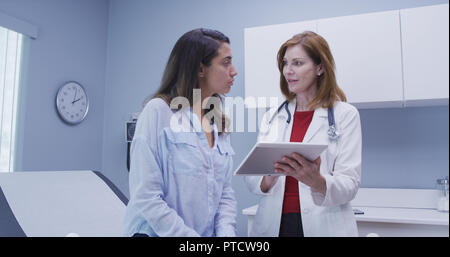 Closeup of doctor using high tech tablet to review health history with patient Stock Photo