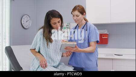 Middle aged medical nurse asking patient questions about general health Stock Photo