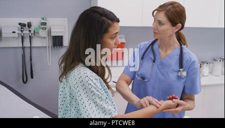 Senior medical nurse using two finger method to check blood rate of patient Stock Photo