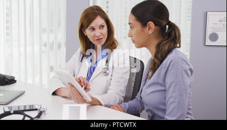 Senior doctor using tablet to share results of patients health condition Stock Photo