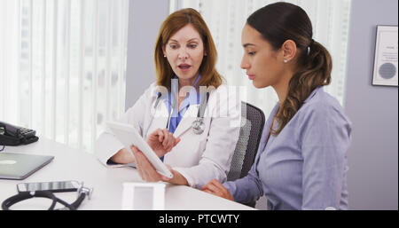 Senior doctor using tablet to share results of patients health condition Stock Photo