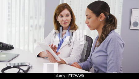 Senior doctor using tablet to share results of patients health condition Stock Photo