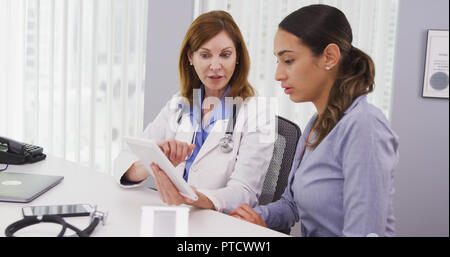 Senior doctor using tablet to share results of patients health condition Stock Photo