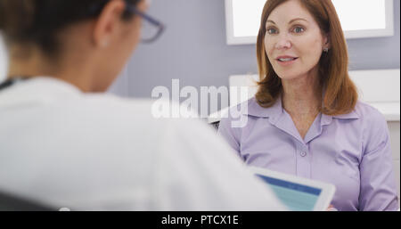 Close up of lovely senior patient talking with young female medical doctor Stock Photo