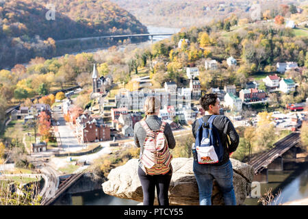 Harper's Ferry, USA - November 11, 2017: Hikers women, people, couple standing at overlook with colorful orange yellow foliage fall autumn forest with Stock Photo