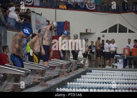 (July 8, 2017) Members of the 2017 Warrior Games line up at the blocks as they prepare for the swim competition at the University of Illinois at Chicago. Team Navy is comprised of athletes from Navy Wounded Warrior - Safe Harbor, the Navy's sole organization for coordinating the non-medical care of seriously wounded, ill, and injured Sailors and Coast Guard members, providing resources and support to their families. Stock Photo